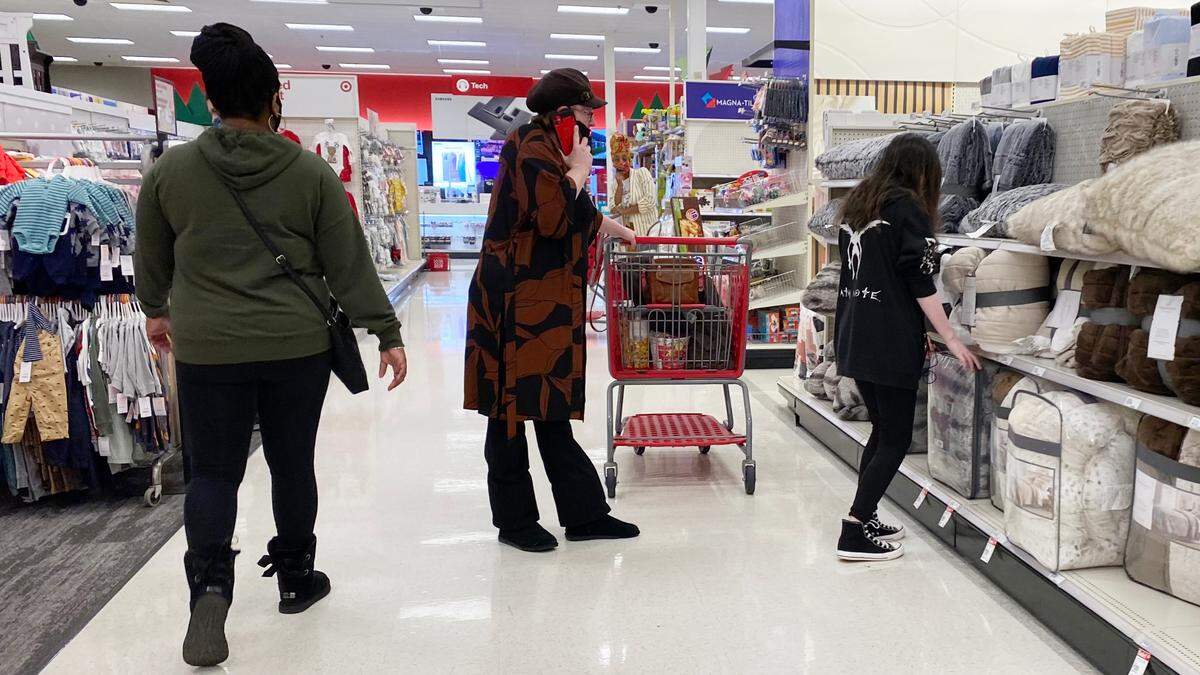 A woman, left, walks past another woman who’s talking on a cellphone and wearing a mask under her nose at Target in Garner’s White Oak on Dec. 8, 2020. About 26 customers were observed either not wearing masks or wearing them incorrectly inside the store around 4 p.m. that afternoon.