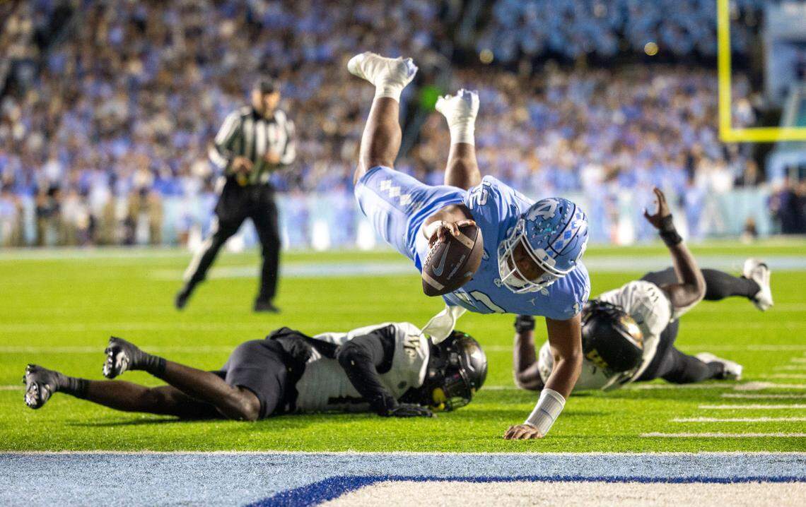 North Carolina quarterback Jacolby Criswell (12) dives over Wake Forest defensive back Zamari Stevenson (17) to score on a 4-yard run to give the Tar Heels a 7-3 lead in the second quarter on Saturday, November 16, 2024 at Kenan Stadium in Chapel Hill, N.C.