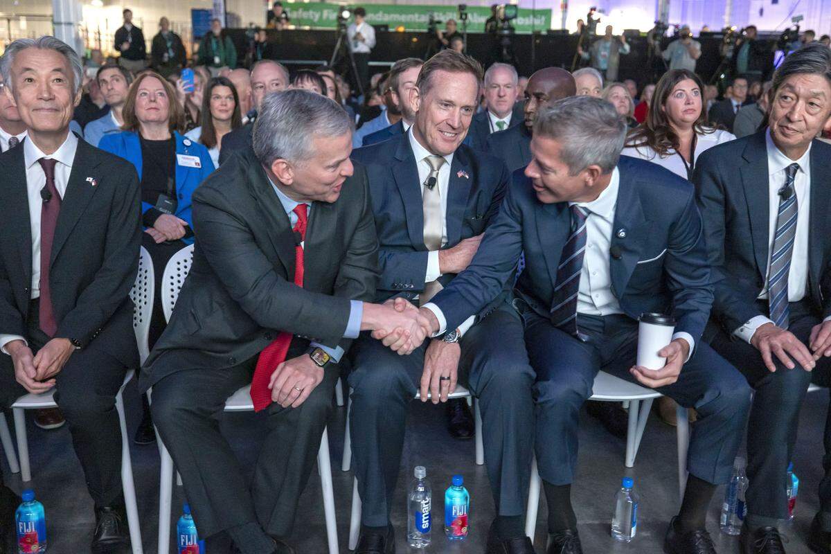 N.C. Governor Josh Stein, left center, shakes hands with U.S. Secretary of Transportation Sean Duffy, right, while sitting with US Senator Ted Budd, center, and Japanese Ambassador to the United States Shigeo Yamada, during a celebration of production at Toyota’s $13.9 billion battery plant on November 12, 2025 in Liberty, N.C. 