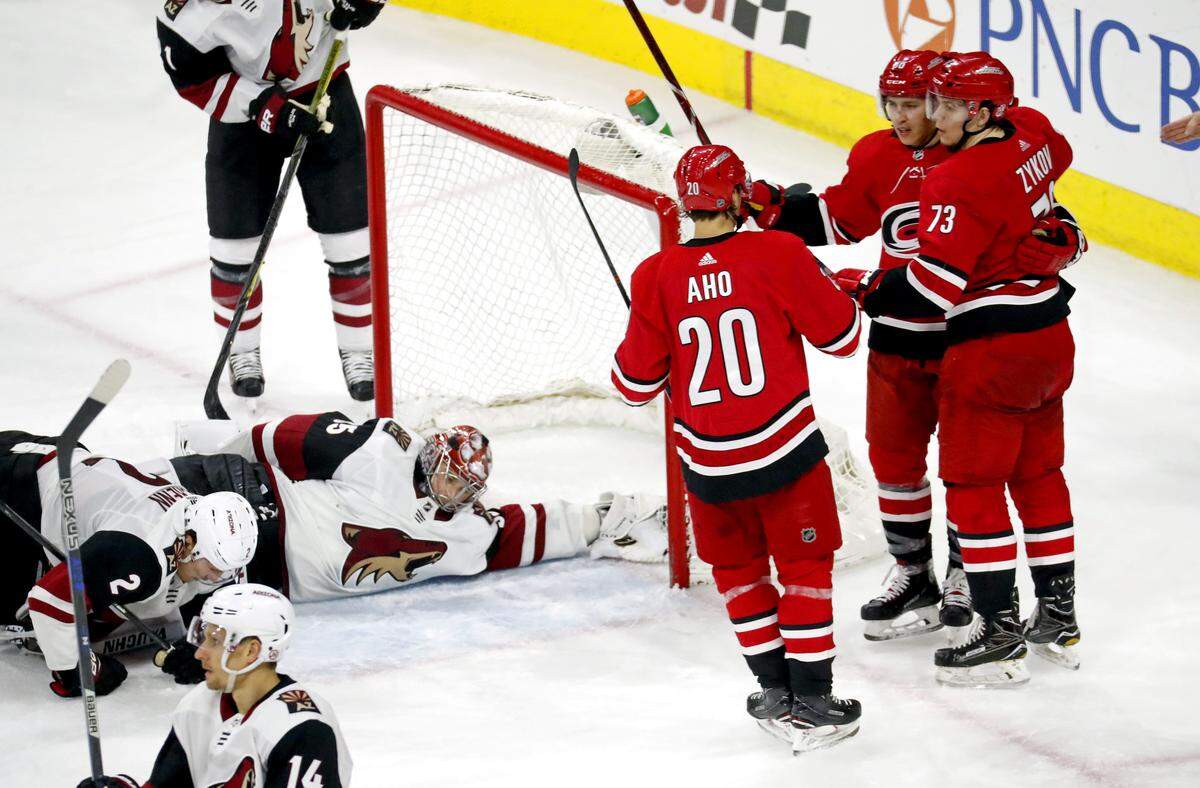 The Canes' Valentin Zykov (73) celebrates his second goal of the game with Sebastian Aho (20) and Teuvo Teravainen (86) after he scored against the Coyotes' Darcy Kuemper (35) and Luke Schenn (2) during the third period.  The Canes beat the Coyotes 6-5.