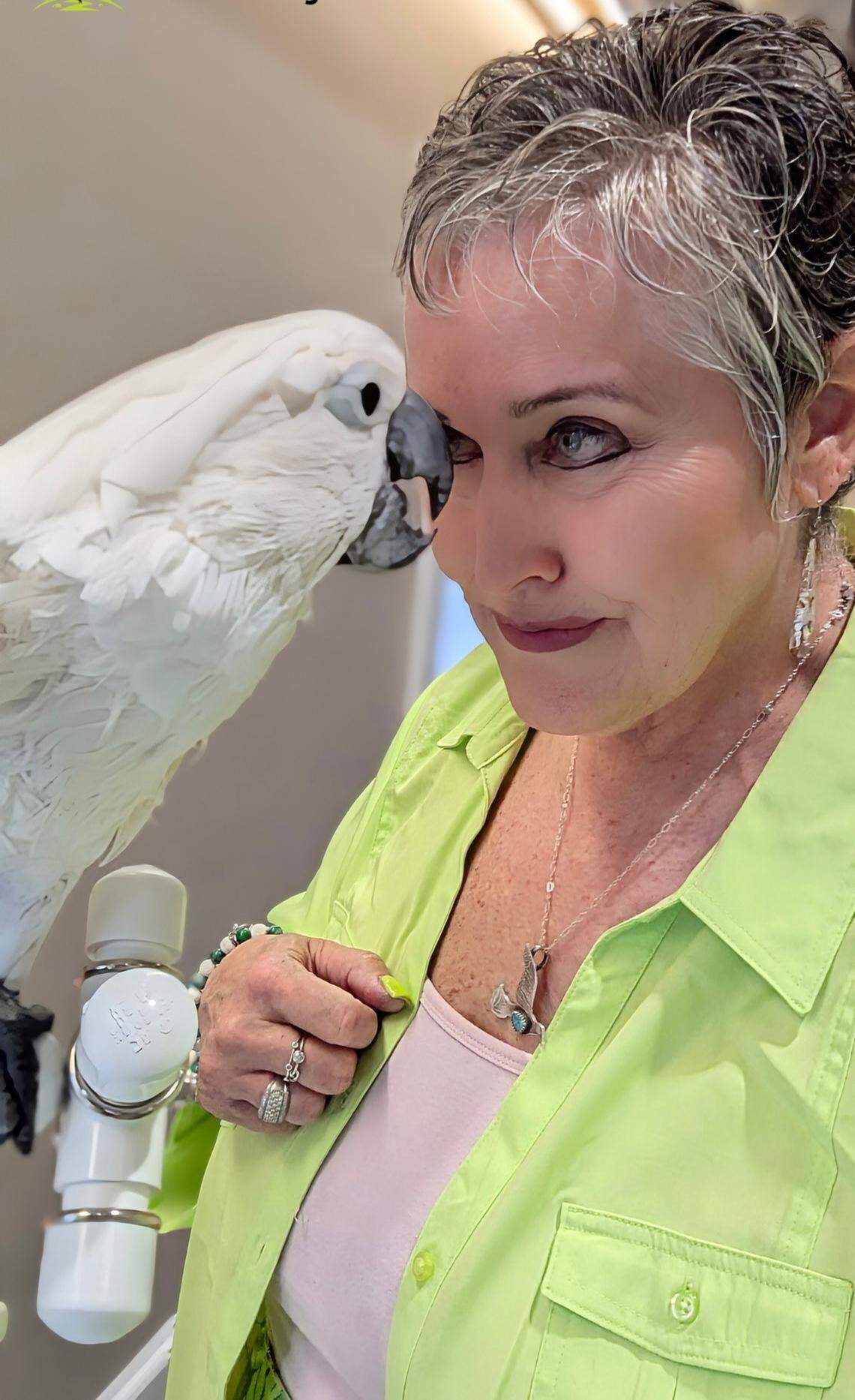 Amy Hurst of Smithfield, Va., bonds with her cockatoo, Boo, after successful cataract surgery at NC State University veterinary hospital.