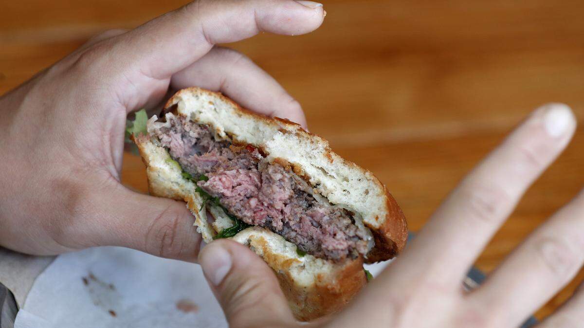 Mark Christmann of Greensboro eats a Tarantula Burger at Bull City Burger and Brewery in Durham, N.C., Thursday, April 19, 2018. The burger is a 6 oz. pasture-raised NC beef burger, with gruyere cheese, spicy chili sauce and an oven-baked tarantula.