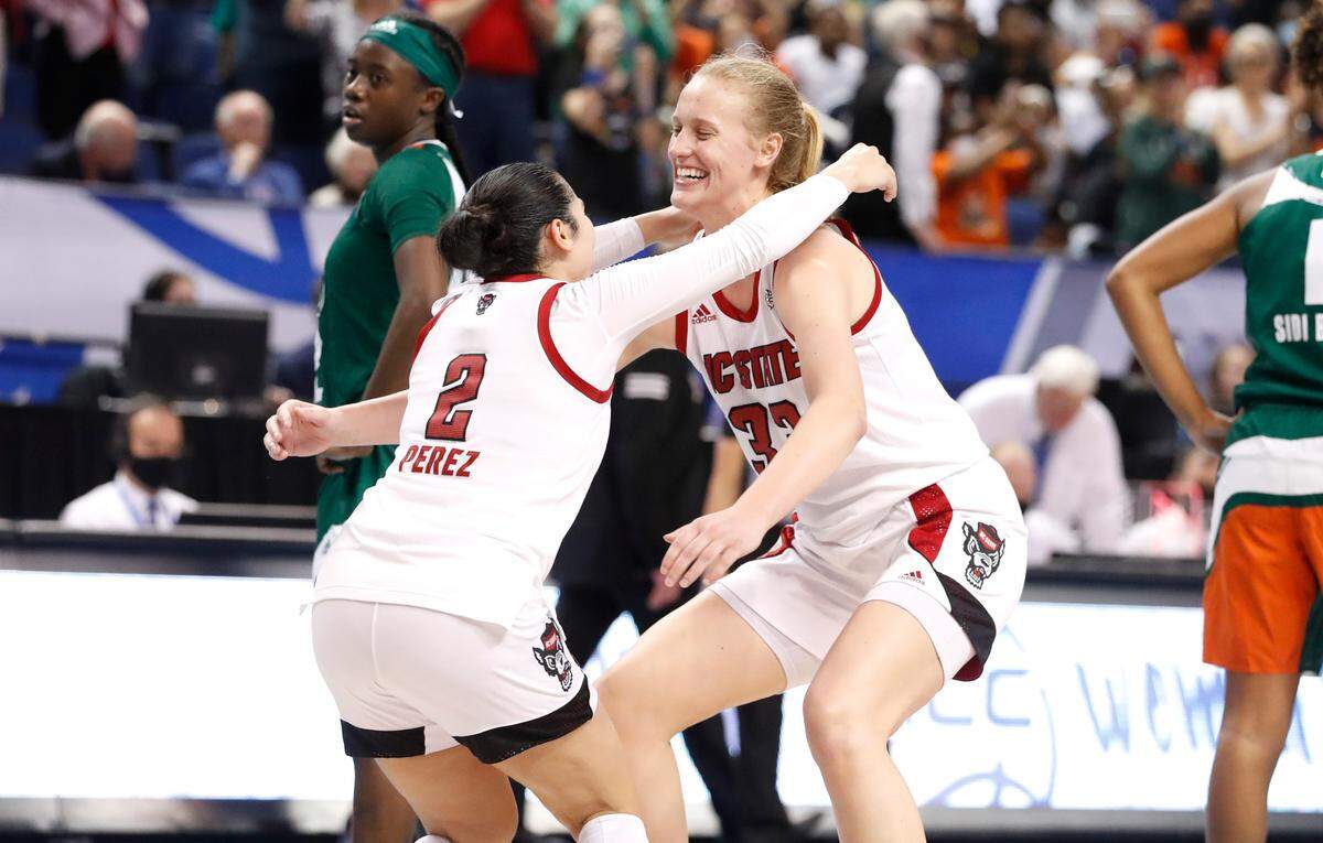 N.C. State’s Raina Perez (2) heads to hug Elissa Cunane (33) after the Wolfpack’s victory over Miami to win the ACC women’s basketball tournament in Greensboro, N.C., Sunday, March 6, 2022.