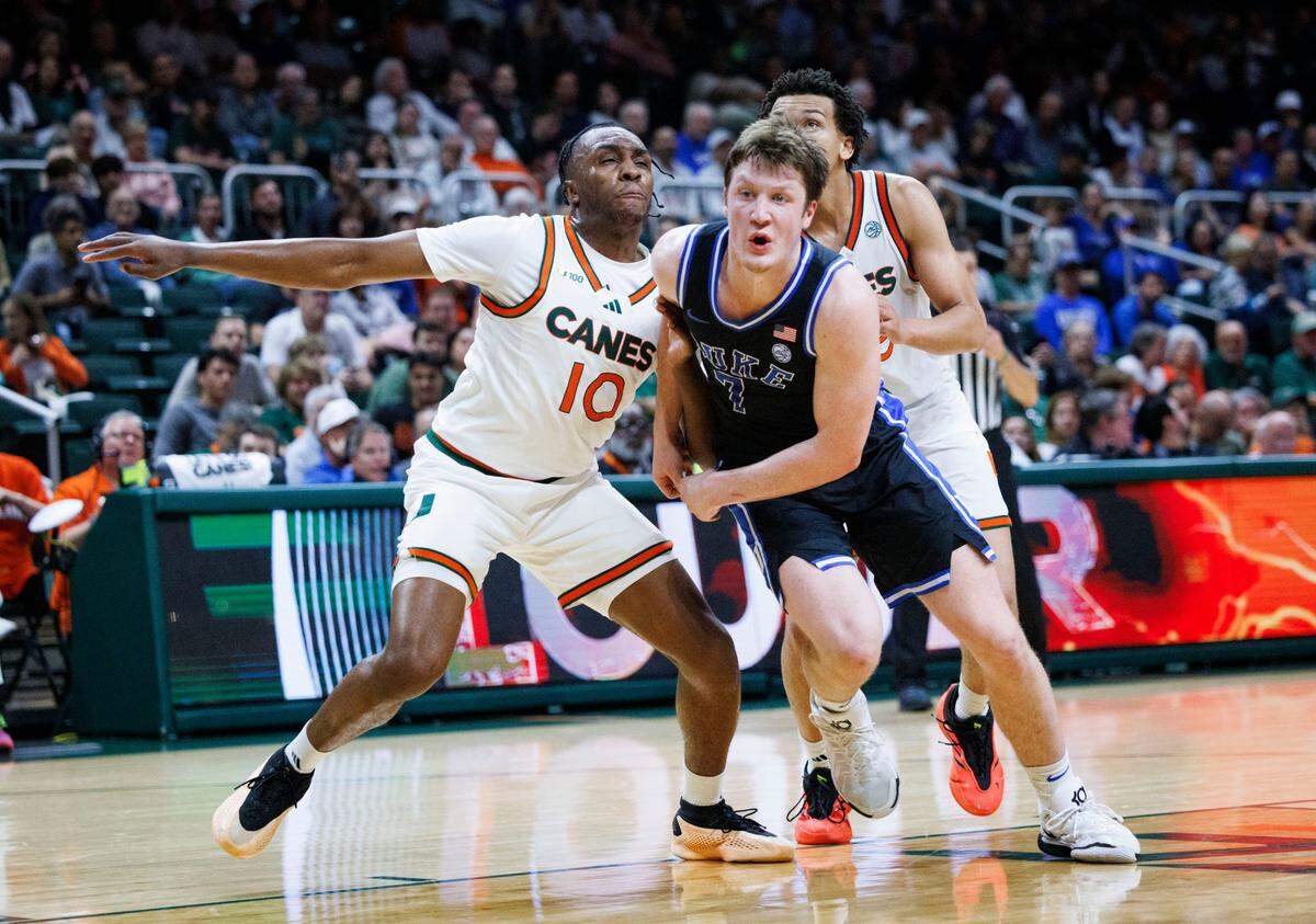 Duke Blue Devils guard Kon Knueppel (7) and Miami (Fl) Hurricanes guard Paul Djobet (10) go after a rebounded free throw during the first half of a game on Tuesday, Feb. 25, 2025, at Watsco Center in Coral Gables, Fla.