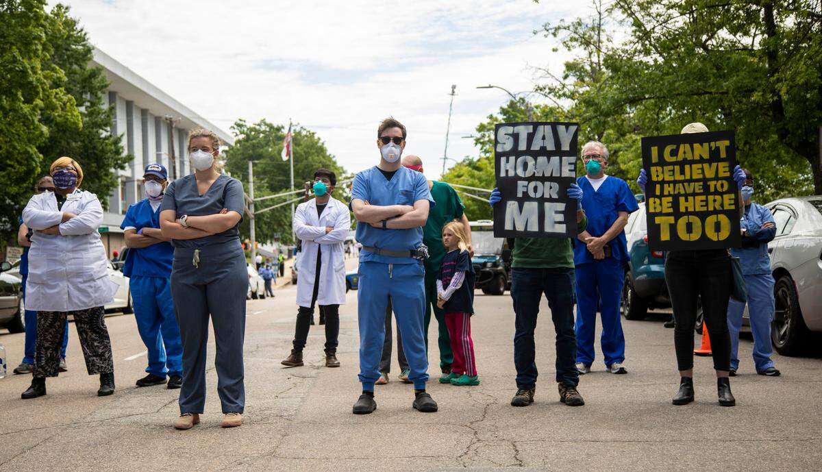 Counter-protesters stand outside North Carolina Legislative Building during a Reopen NC rally in downtown Raleigh Tuesday, April 28, 2020. Protesters were calling for Gov. Roy Cooper to end the restrictions put in place because of the coronavirus pandemic.