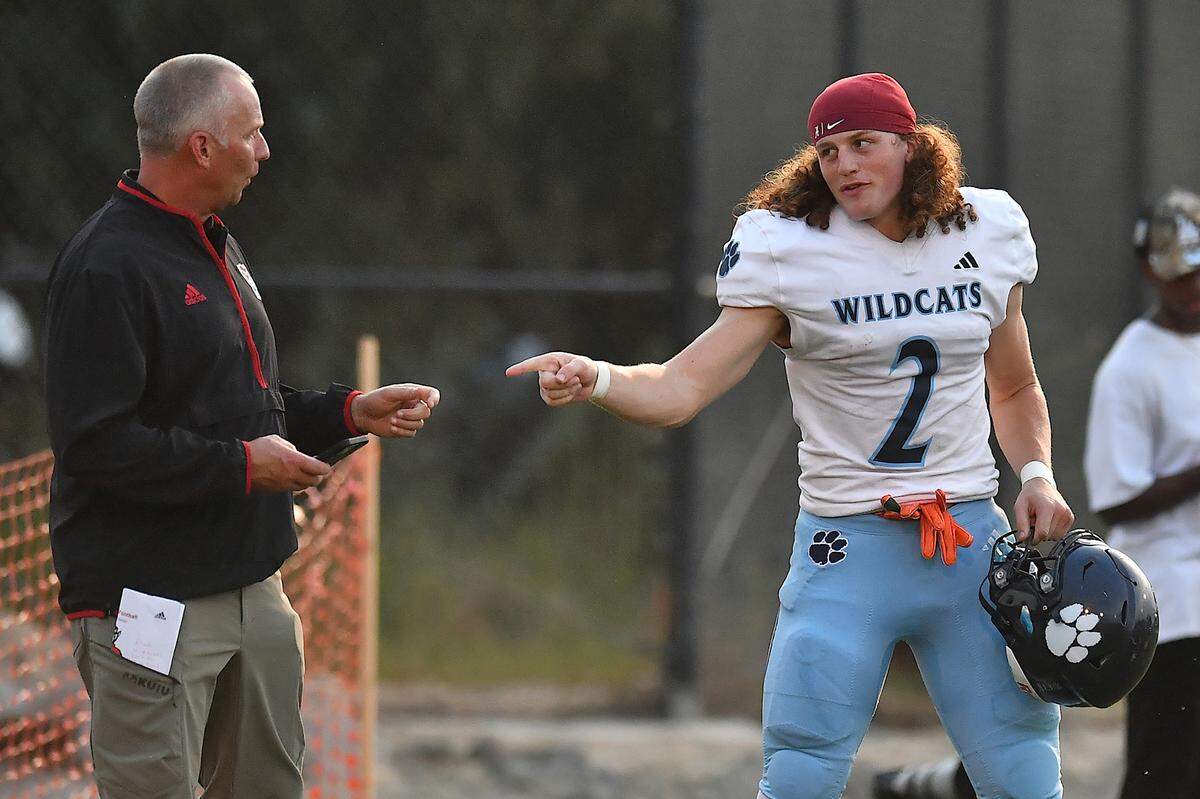 Millbrook linebacker Quinton Cypher (2) talks with N.C. State Head Football Coach Dave Doeren before the start of the game against Rolesville. The Millbrook Wildcats and the Rolesville Rams met in a conference football game in Rolesville, N.C. September 26, 2025