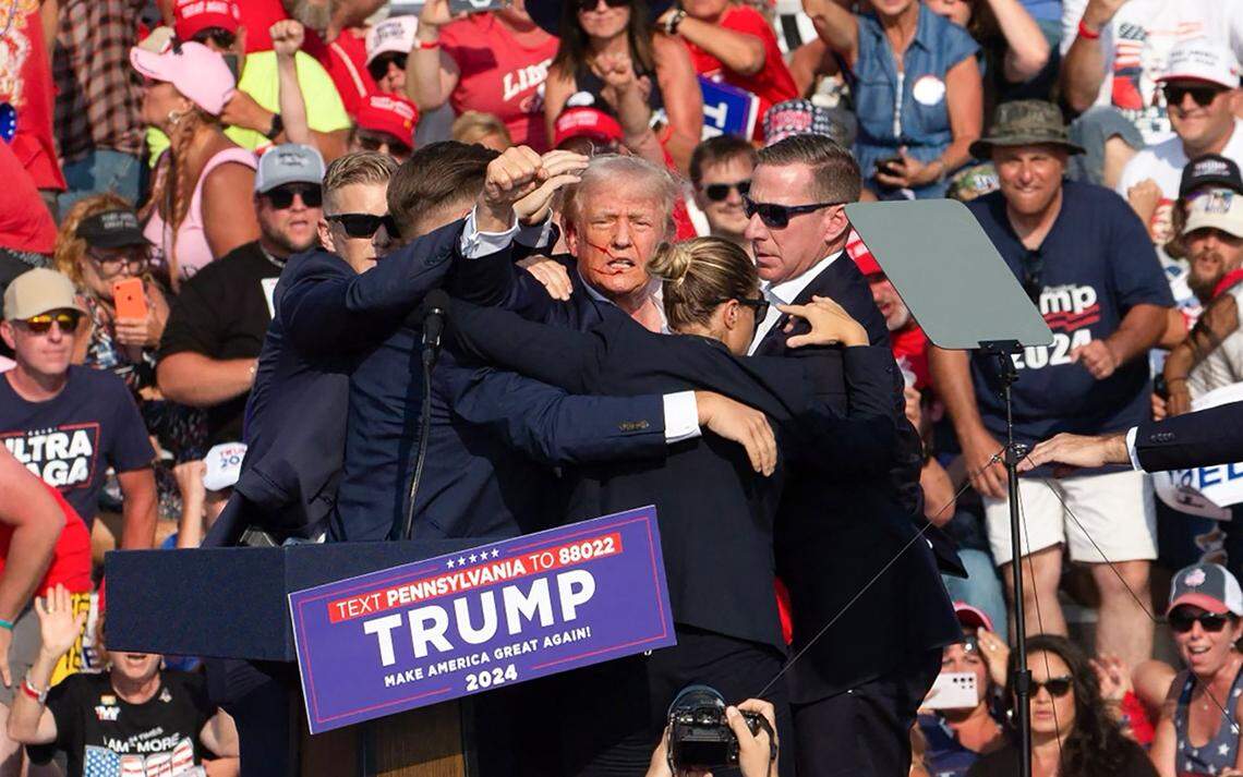 Former President Donald Trump is surrounded by Secret Service agents after a shooting at a campaign event at Butler Farm Show Inc. in Butler, Pennsylvania, on Saturday, July 13, 2024.