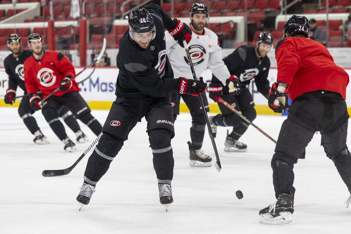 Carolina Hurricanes defenseman Sean Walker (26) clears the puck away from teammate center Seth Jarvis (24) during practice on Tuesday, May 12, 2026, at Lenovo Center in Raleigh, N.C.