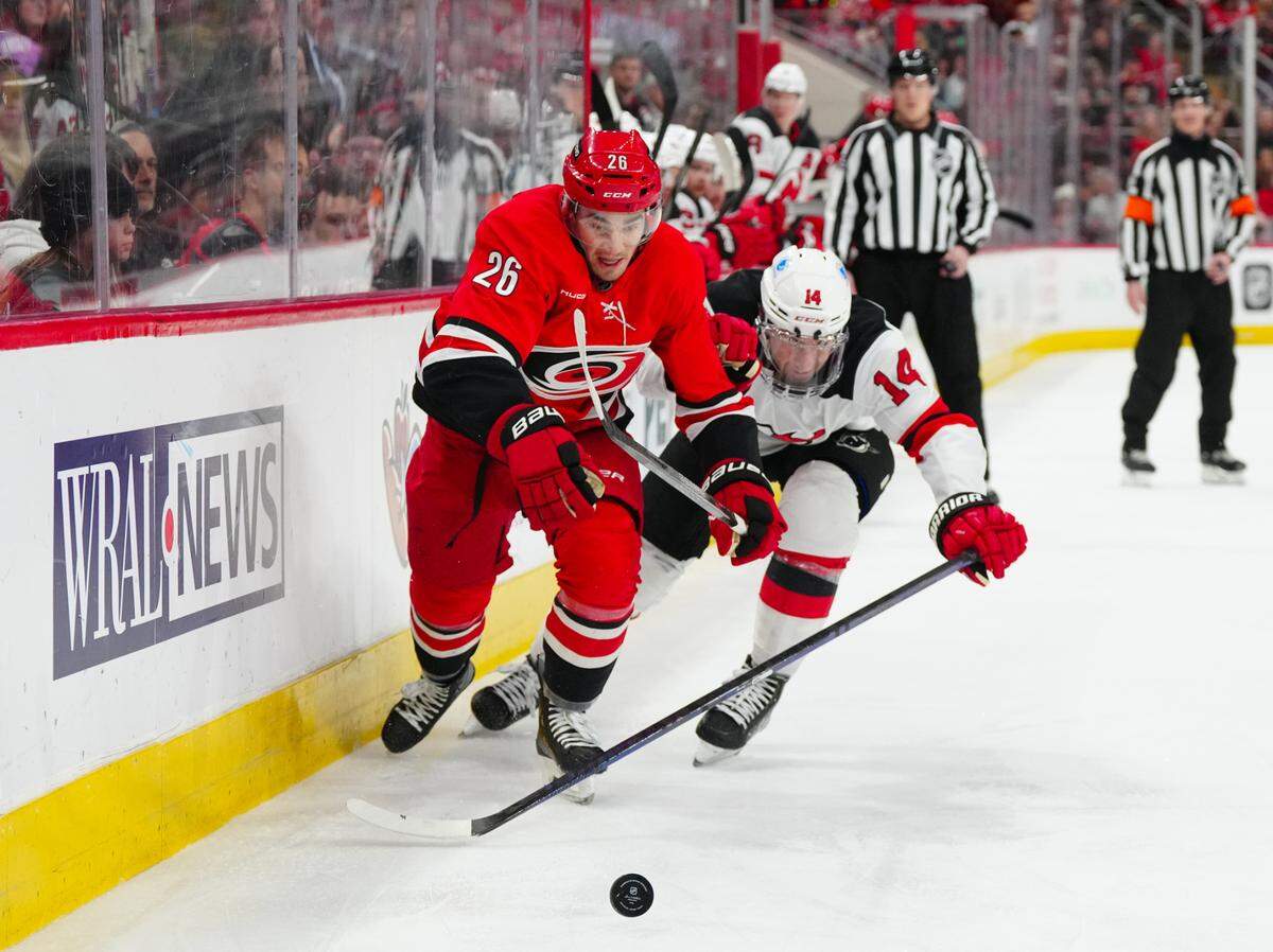 Carolina Hurricanes defenseman Sean Walker (26) and New Jersey Devils right wing Nathan Bastian (14) battle over the puck during the first period at Lenovo Center.