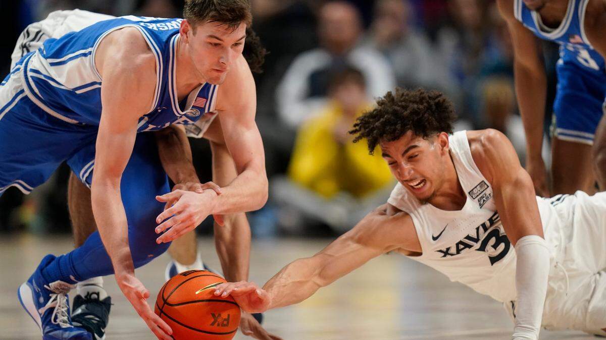 Duke’s Kyle Filipowski, left, and Xavier guard Colby Jones (3) battle for the ball during the second half of an NCAA college basketball game in the Phil Knight Legacy tournament Friday, Nov. 25, 2022, in Portland, Ore. (AP Photo/Rick Bowmer)