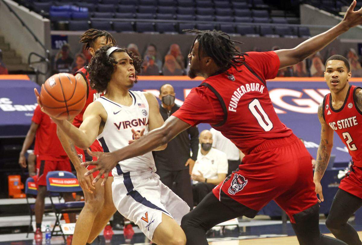 Virginia guard Kihei Clark (0) is pressured by North Carolina State forward DJ Funderburk (0) during the game Wednesday in Charlottesville, Va.