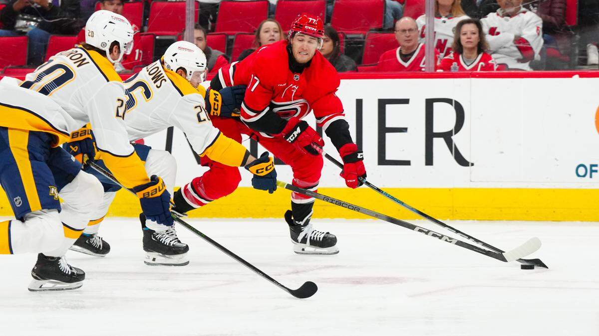 Carolina Hurricanes center Mark Jankowski (77) skates with the puck past Nashville Predators left wing Kieffer Bellows (26) during the first period at Lenovo Center on Tuesday, March 25, 2025.