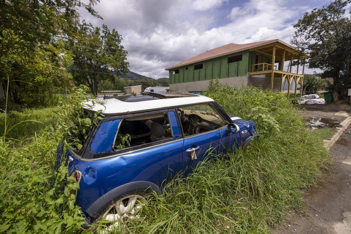 A flooded-out and abandoned Mini Cooper sits near the nearly rebuilt home of Daniel and Mariah Wright in mid-August. 