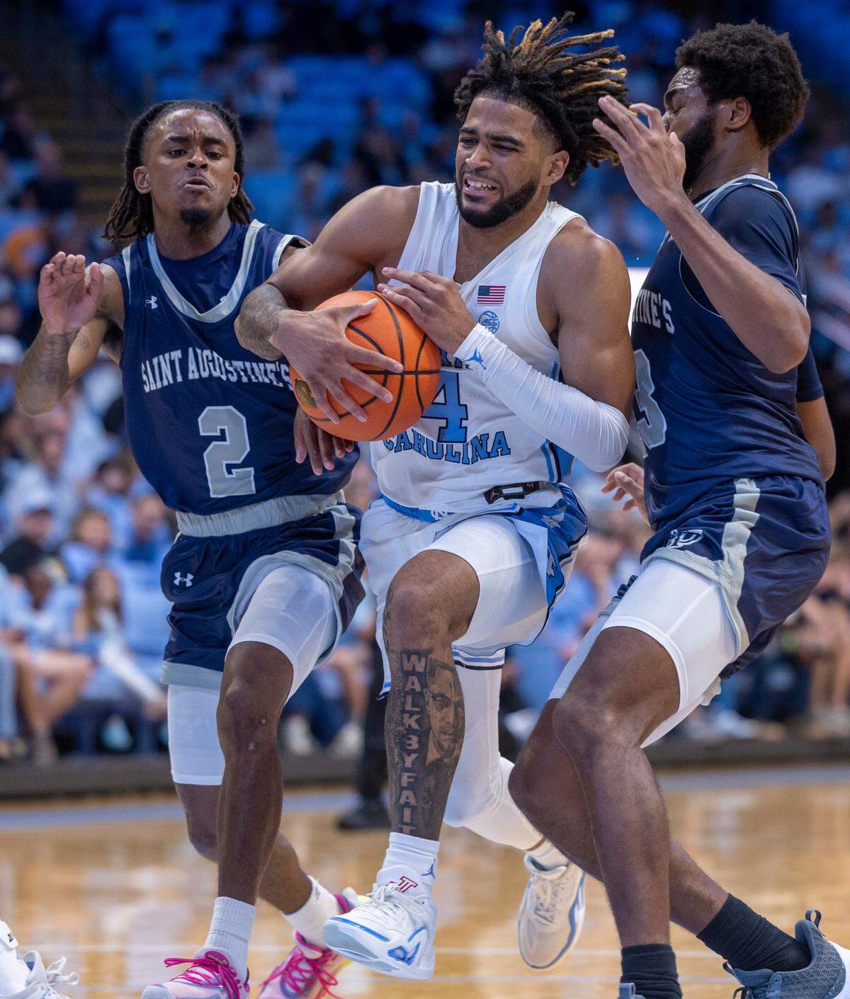North Carolina’s R.J. Davis (4) protects the ball as he drives to the basket between St. Augustine’s Joshua Johnson (2) and Jalen Williams (23) in the first half on Friday, October 27, 2023 at the Smith Center in Chapel Hill, N.C.