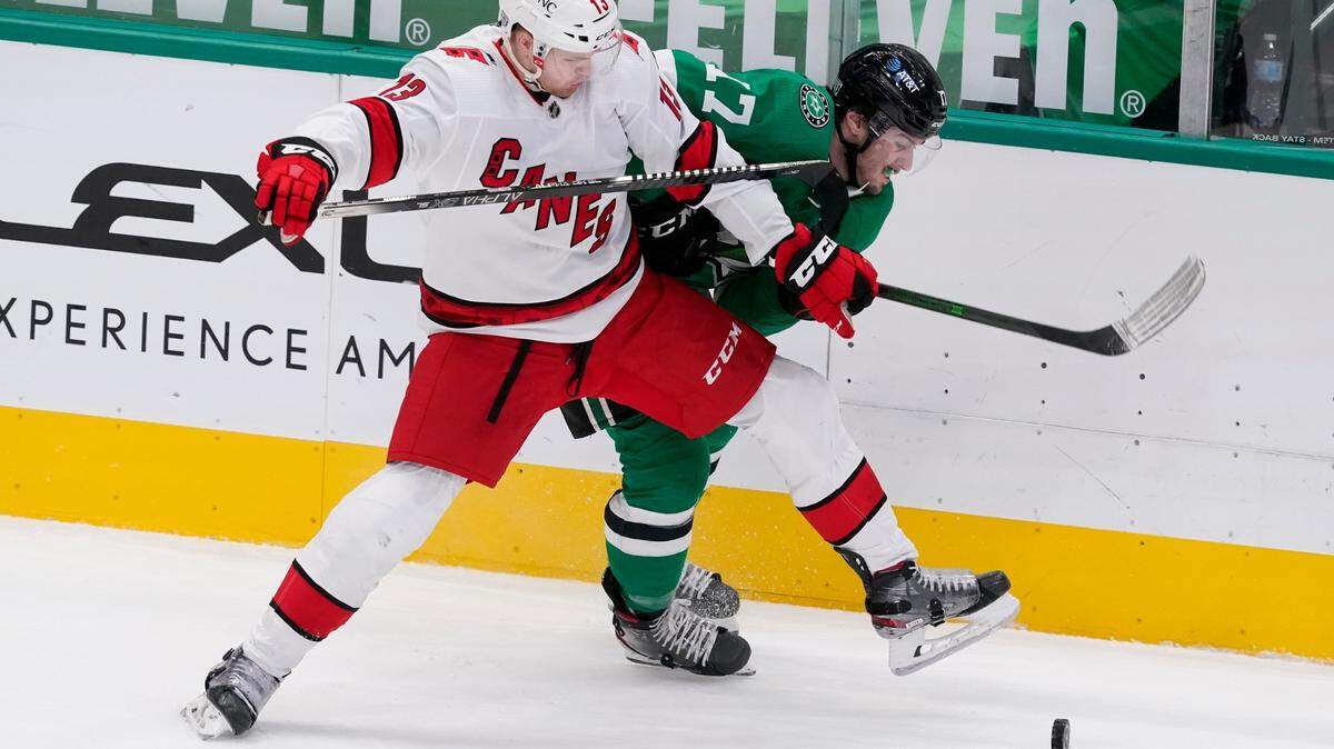 Carolina Hurricanes’ Warren Foegele (13) and Dallas Stars’ Nick Caamano (17) compete for control of the puck in the first period of an NHL hockey game in Dallas, Thursday, Feb. 11, 2021. (AP Photo/Tony Gutierrez)