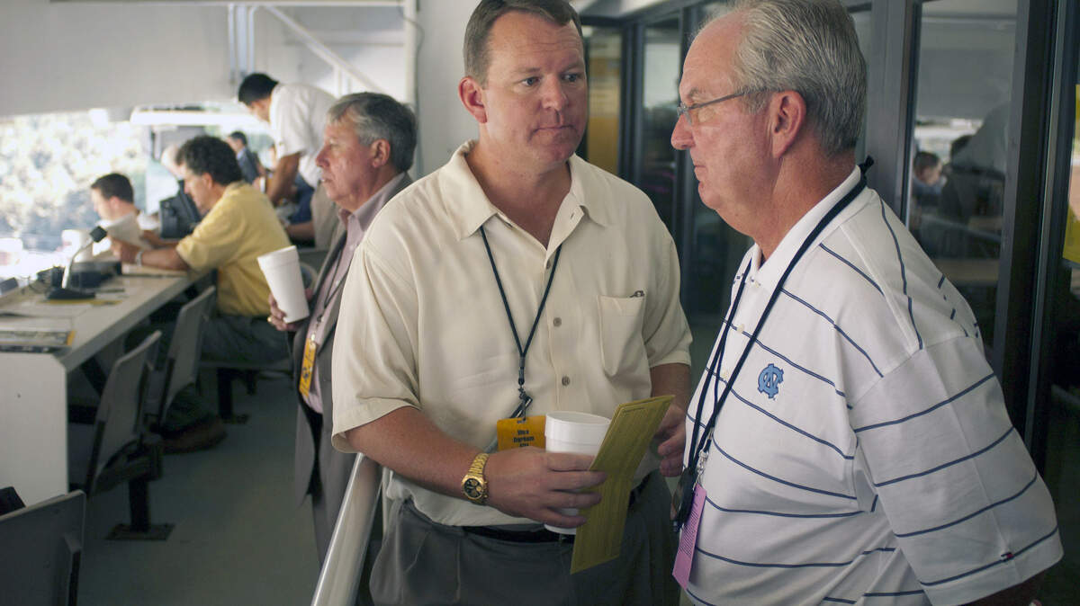 Wes Durham talks with his father Woody Durham prior to the North Carolina vs. Georgia Tech football game on September 10, 2004 in Atlanta, Ga. Wes Durham called the game for the Georgia Tech radio network, and Woody for the North Carolina network.