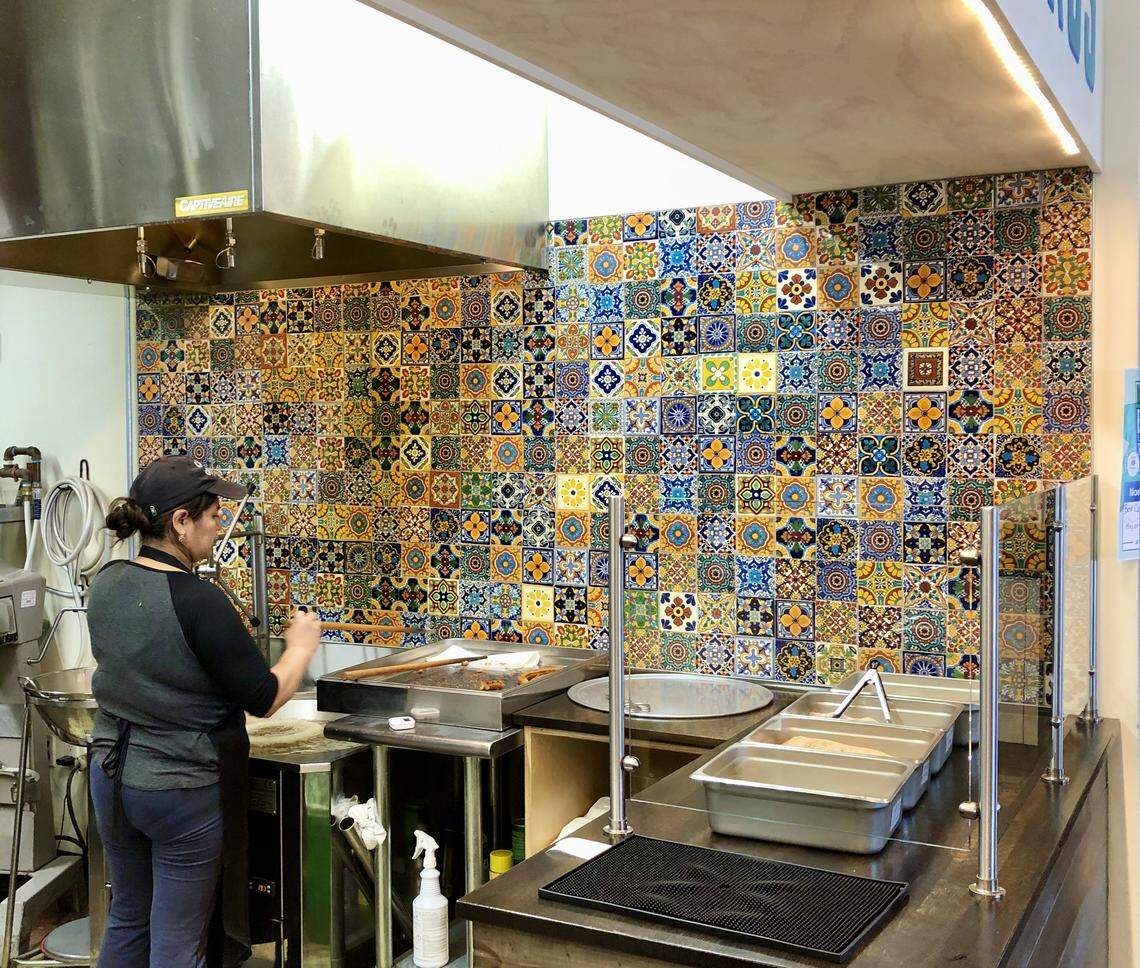 An employee makes churros at Cocoa Cinnamon in Durham on March 16, 2020.