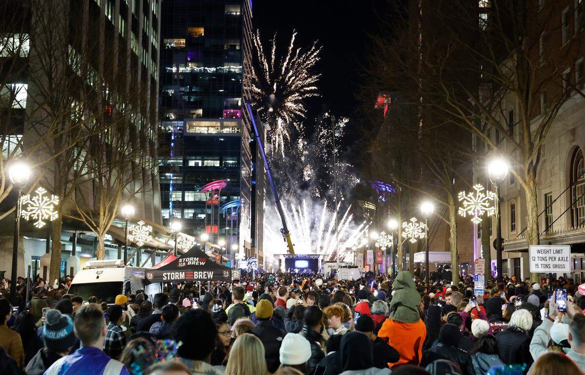 Revelers on Fayetteville Street watch as fireworks welcome the new year after the acorn drop at First Night Raleigh early Monday morning, Jan. 1, 2024.