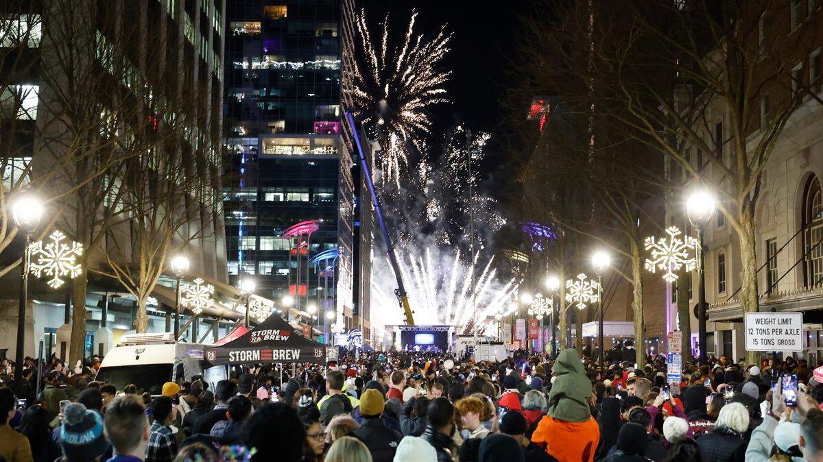 Revelers on Fayetteville Street watch as fireworks welcome the new year after the acorn drop at First Night Raleigh on Jan. 1, 2024.