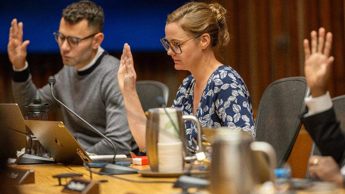 Raleigh City Council members, from left, Jonathan Melton, Megan Patton, and Corey Branch, vote to close South Street and move the Red Hat Amphitheater to make way for the Convention Center expansion, during the council meeting on Sept. 17, 2024.
