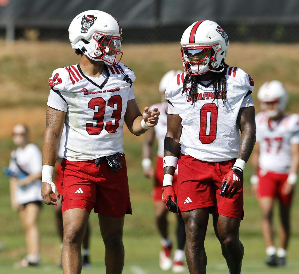 N.C. State’s Kenny Soares, Jr. (33) talks with Sean Brown (0) during the Wolfpack’s first fall practice Wednesday, July 30, 2025.
