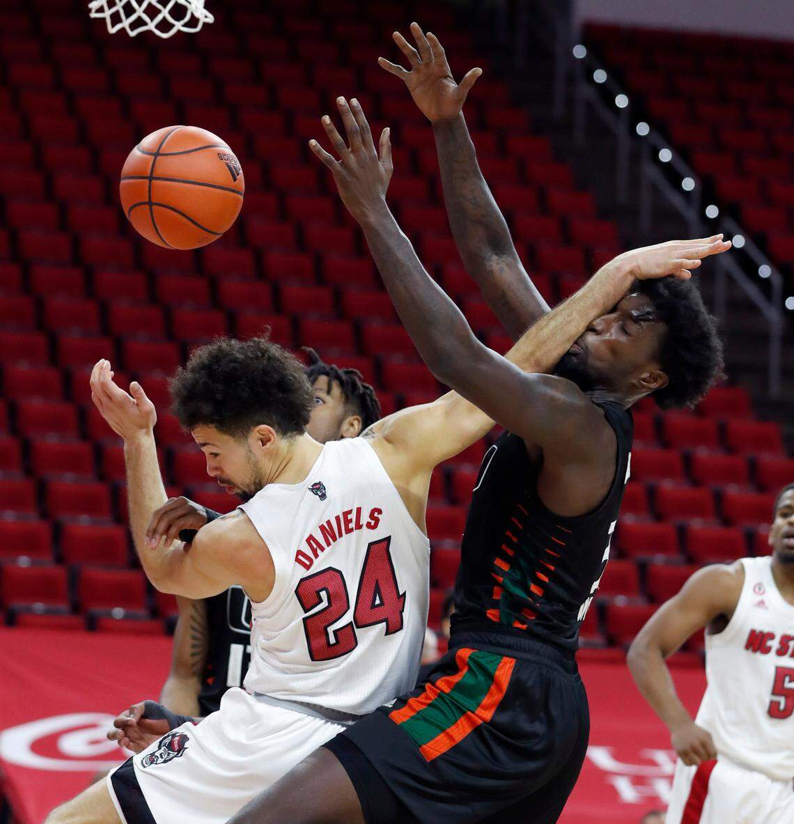 N.C. State’s Devon Daniels (24) and Miami’s Nysier Brooks (3) fight for the rebound during the second half of Miami’s 64-59 victory over N.C. State at PNC Arena in Raleigh, N.C., Saturday, January 9, 2021.