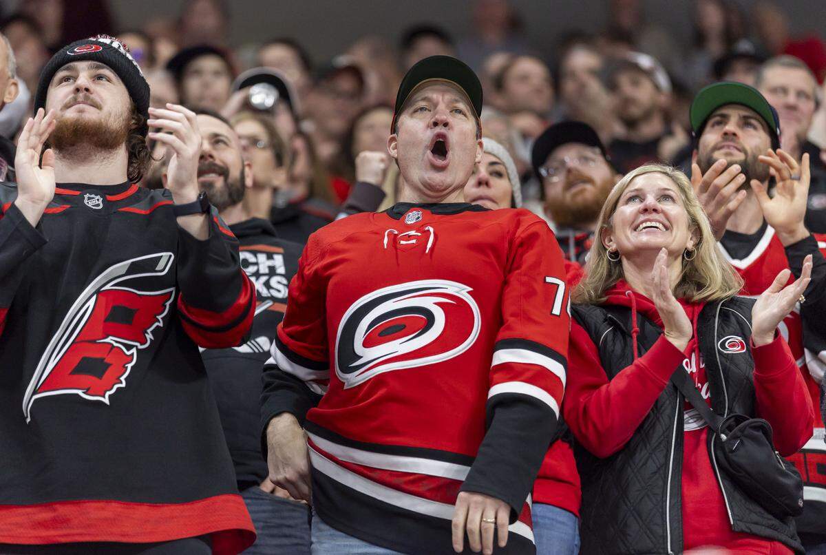 Carolina Hurricanes fans react after a goal by Shayne Gostisbehere (4) in the first period against the Dallas Stars on Tuesday, January 6, 2026 at Lenovo Center in Raleigh, N.C.