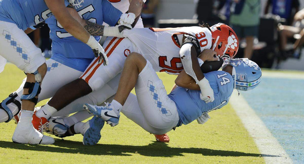 North Carolina quarterback Max Johnson (14) is sacked by Clemson defensive tackle Stephiylan Green (90) during the first half of UNC’s game against Clemson at Kenan Stadium in Chapel Hill, N.C., Sat. Oct. 4, 2025.
