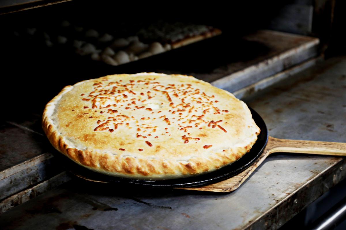 A browned stuffed pizza comes out of the oven during lunch at J & S New York Pizza in Cary on Friday, Aug. 2, 2019.