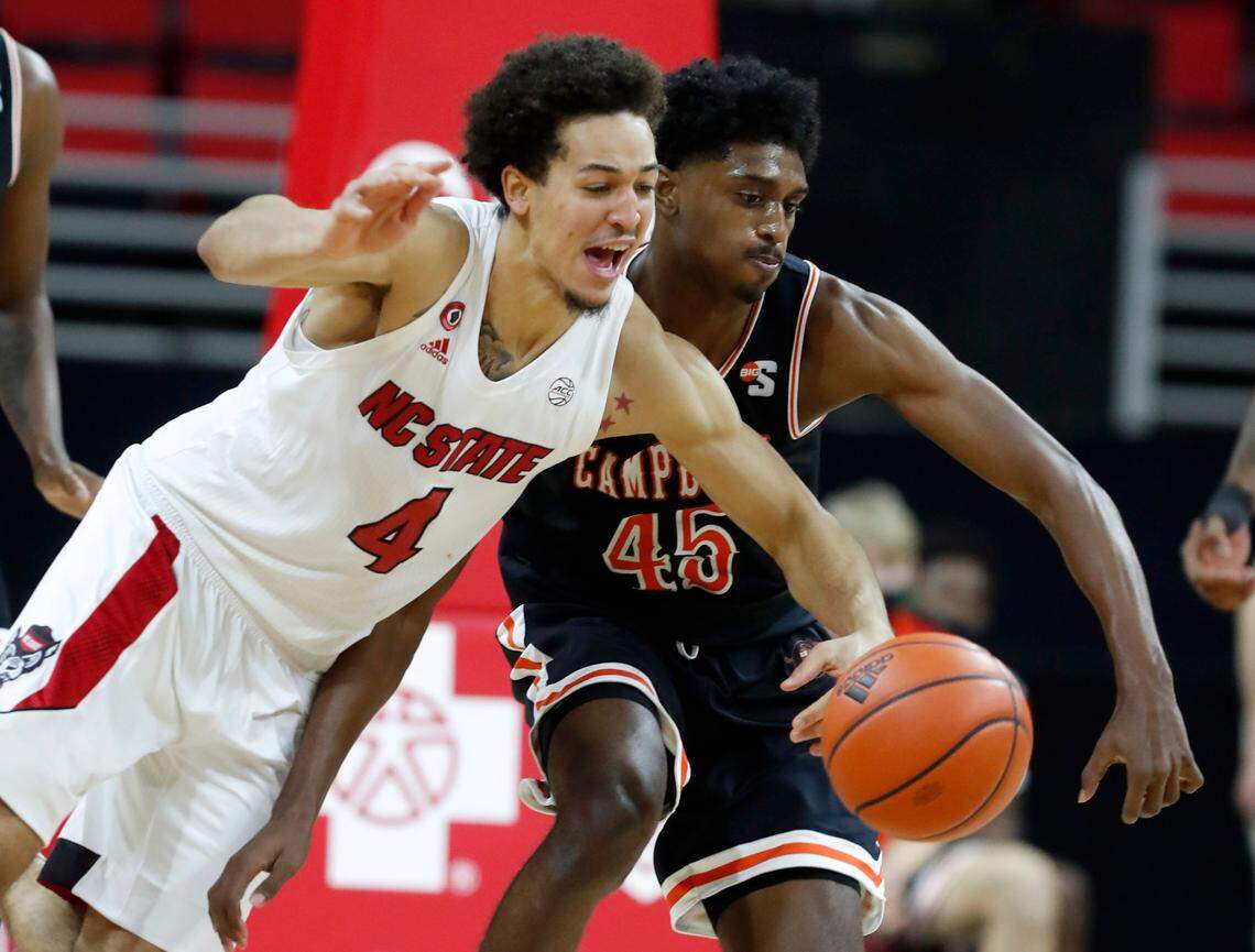 N.C. State’s Jericole Hellems (4) battles Campbell’s Cedric Henderson Jr. (45) for a loose ball during the second half of N.C. State’s 69-50 victory over Campbell at PNC Arena in Raleigh, N.C., Saturday, Dec. 19, 2020.