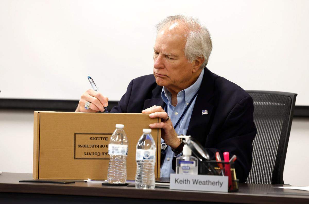 Wake County Board of Elections board member Keith Weatherly signs a box with ballots in it during a Wake County Board of Elections board meeting at the operations center in Raleigh, N.C., Tuesday, May 7, 2024.