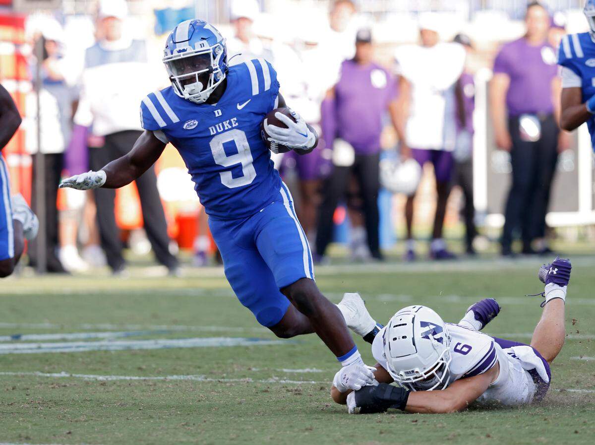 Duke’s Jaquez Moore runs the ball under pressure from Northwestern’s Robert Fitzgerald during the second half of the Blue Devils’ 38-14 win on Saturday, Sept. 16, 2023, at Wallace Wade Stadium in Durham, N.C.