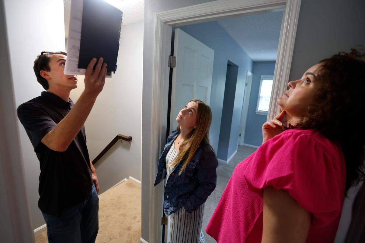 Brandon Thomas, his fiancee Corinne Enlow and Realtor AnnMarie Janni look over a home in Garner while touring houses for sale in Garner and Clayton, N.C. on Tuesday, May 2, 2023.
