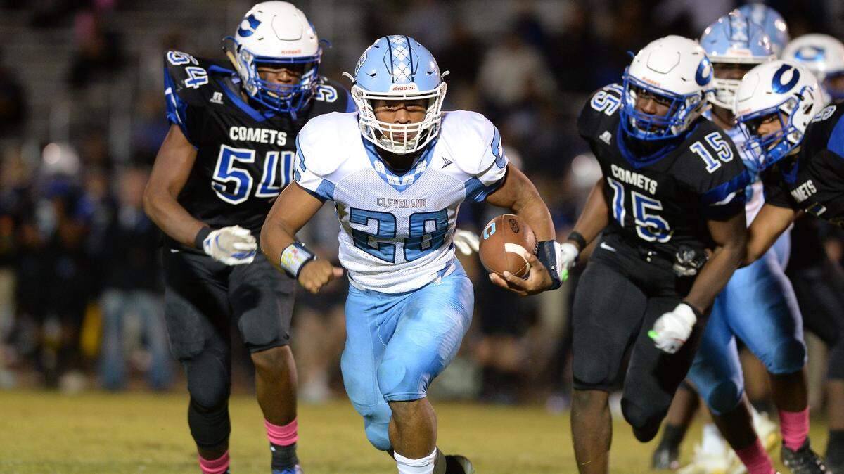 Omarion Hampton (28) of Cleveland gains yards against Jaden Moore (54) and Emmanuel Johnson (15) of Clayton. The Cleveland Rams visited the Clayton Comets in a high school football game on October 25, 2019.