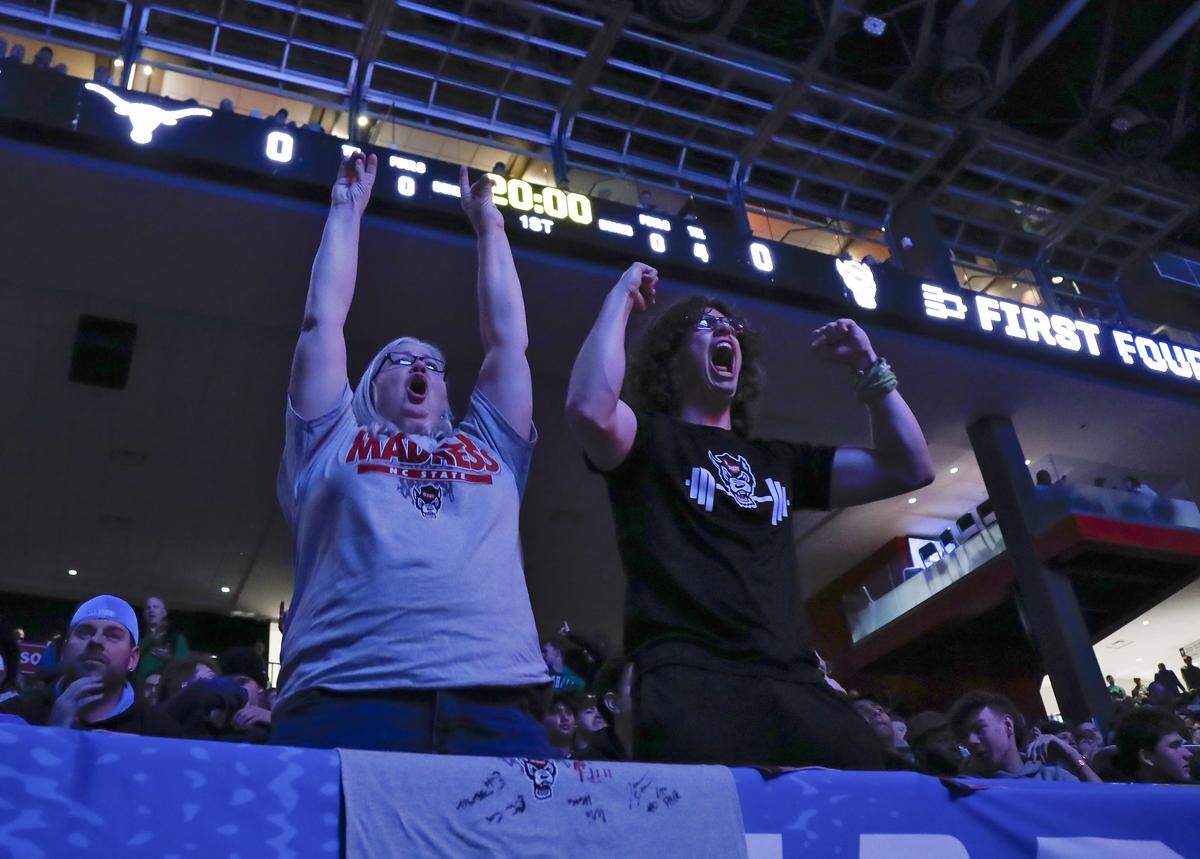 Laura Lee Sherman and her son, N.C. State first year Michael Lee Sherman, cheer during the starting lineups prior to the Wolfpack’s game against Texas in the NCAA First Four on Tuesday, March 17, 2026, at the University of Dayton Arena in Dayton, Ohio. The pair drove to Dayton from Four Oaks, N.C. on Tuesday morning.