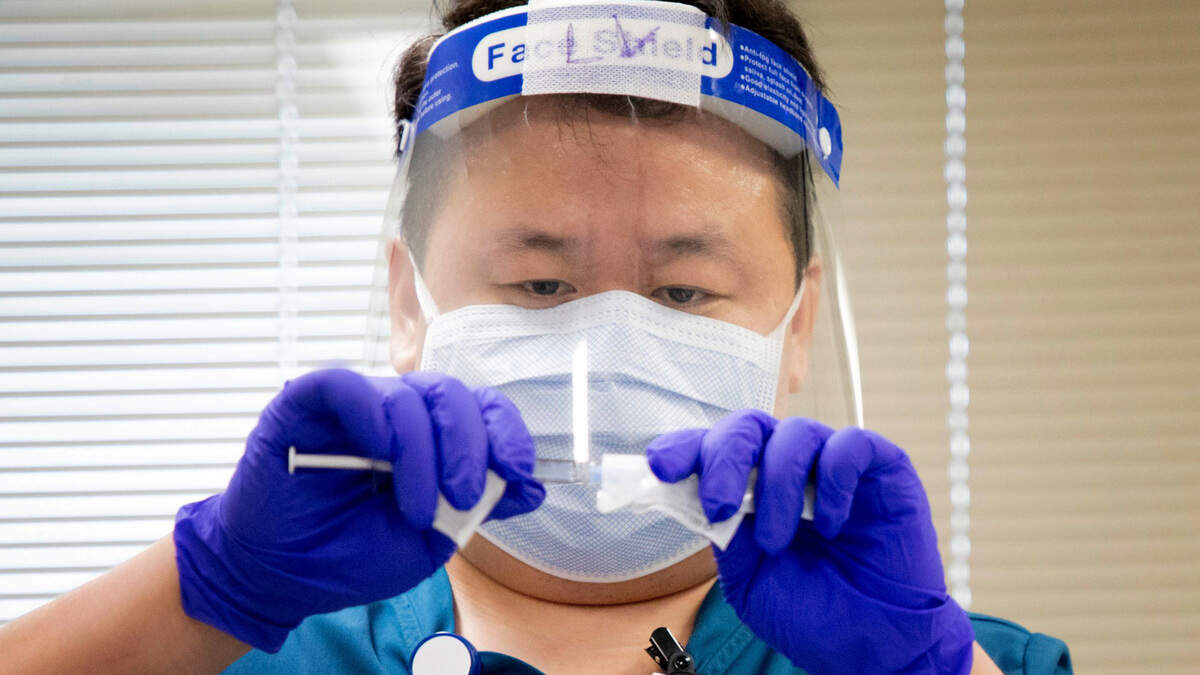 Registered nurse Lue Vang prepares to administer a dose of the Pfizer COVID-19 vaccine on the first morning of its distribution to patients and personnel at the Durham VA Medical Center, on Wednesday, Dec. 16, 2020, in Durham, N.C.