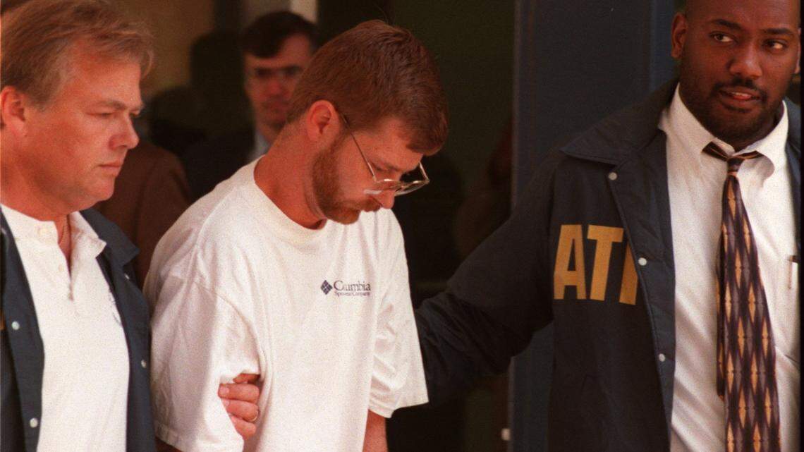 Stephan Bullis (center) is led from the Raleigh Police Department after the July 1995 bombing of the then BTI building in North Raleigh.