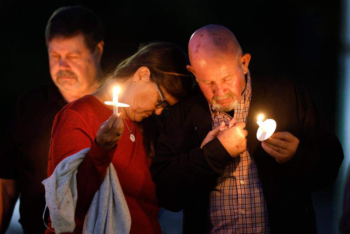 Tommy and Diane Faison pray during a candlelight vigil at Beacon Baptist Church in Raleigh, N.C. Saturday, Oct.15, 2022. The vigil was for those killed and wounded in mass shooting in the Hedingham neighborhood of Raleigh on Thursday.