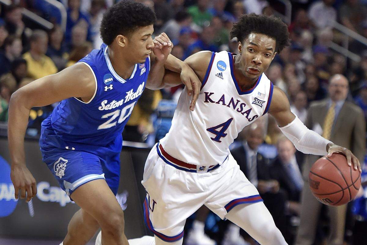 KU's Devonte' Graham battles his way by Seton Hall's Desi Rodriquez on his way to the bucket.