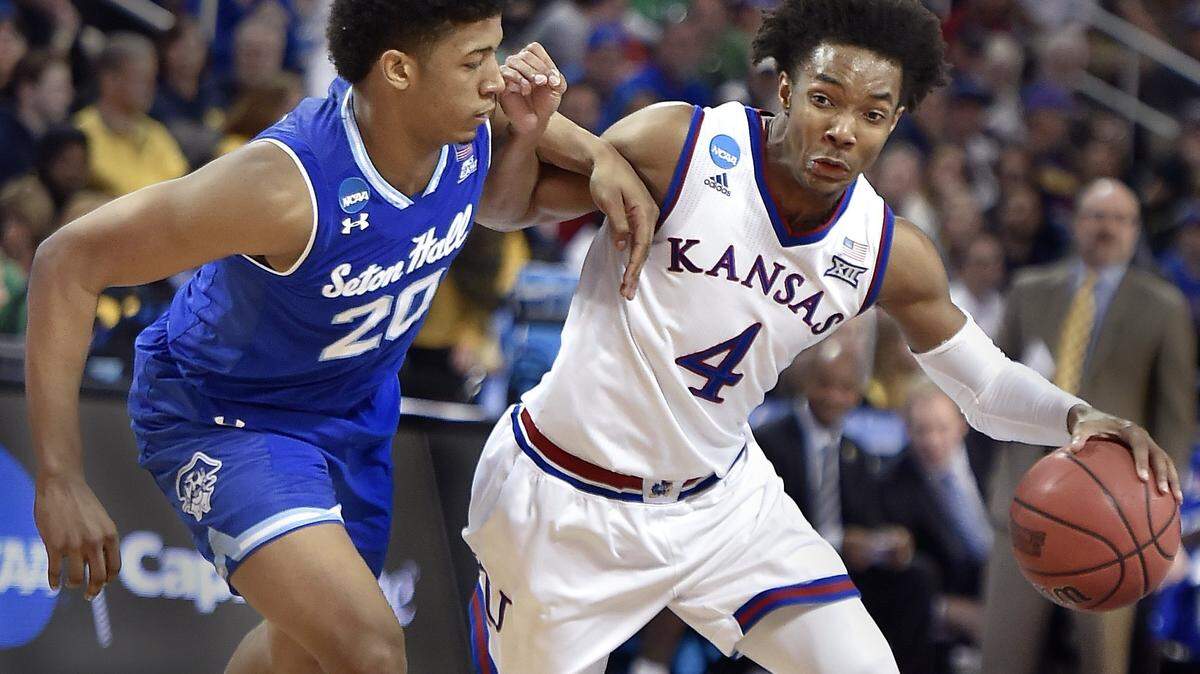 KU's Devonte' Graham battles his way by Seton Hall's Desi Rodriquez on his way to the bucket.