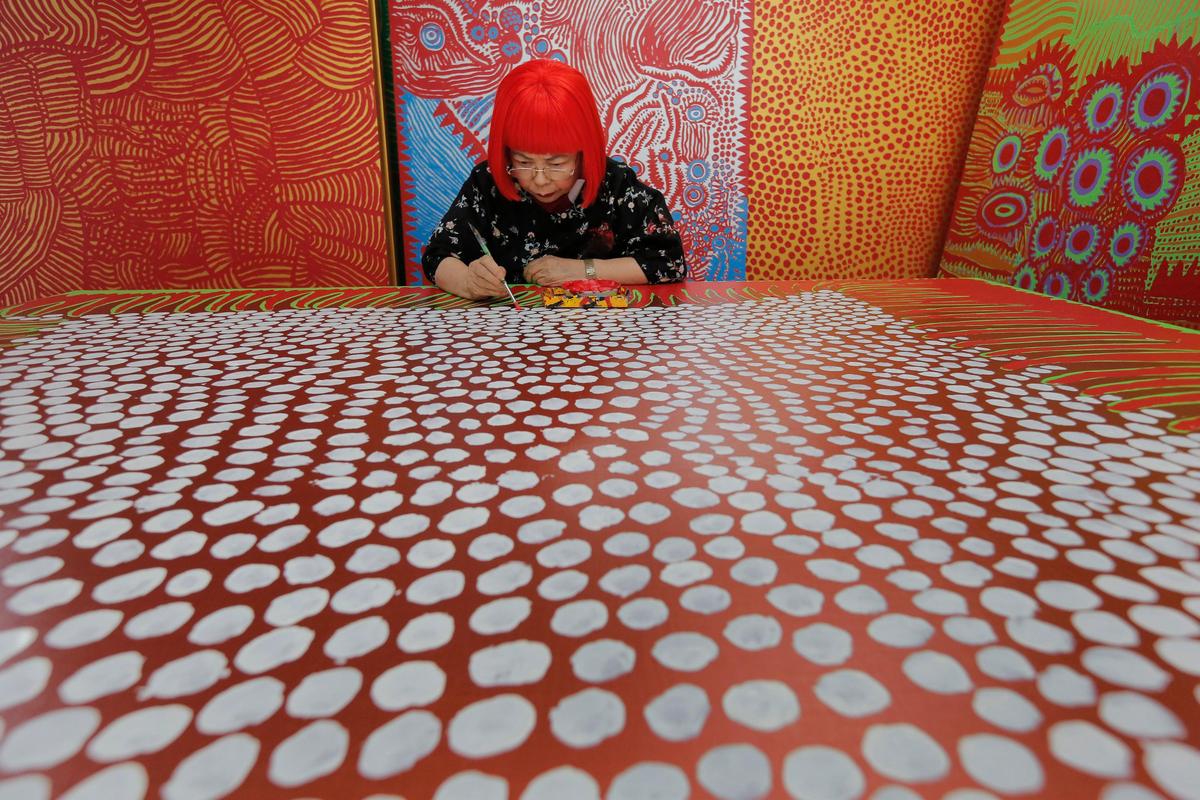 In this photo taken Aug. 1, 2012, Japanese avant-garde artist Yayoi Kusama works at her studio, filled with wall-sized paintings throbbing with her repetitive dots, in Tokyo. She is considered one of the most "Instagrammed artists in the world."