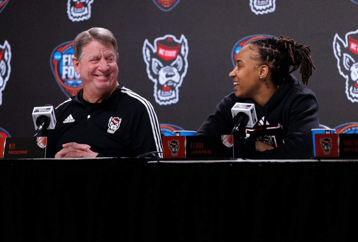 N.C. State head coach Wes Moore smiles as Aziaha James answers a question during a press conference at Rocket Mortgage FieldHouse on Thursday, April 4, 2024, in Cleveland, Ohio. The Wolfpack will face South Carolina in the Final Four on Friday.