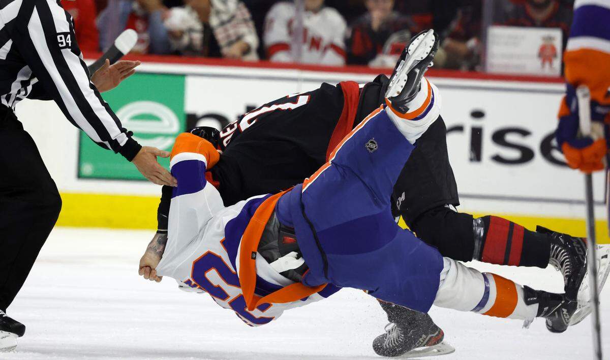 Carolina right wing Stefan Noesen (23) takes down New York center Kyle MacLean (32) as they fight during the first period of the Hurricanes game against the Islanders in the first round of the Stanley Cup playoffs at PNC Arena in Raleigh, N.C., Monday, April 22, 2024.