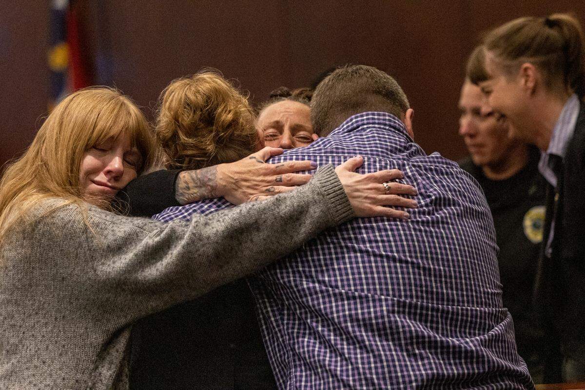 Family and friends embrace Melanie Tucker, the mother of Monica Moynan, center, after Brian Sluss was found guilty in the 2019 murder of his Moynan in Wake County District Court Thursday, April 28, 2022. Moynan, who shared two children with Sluss, was reported missing in mid-July of 2019, and her body has never been found.