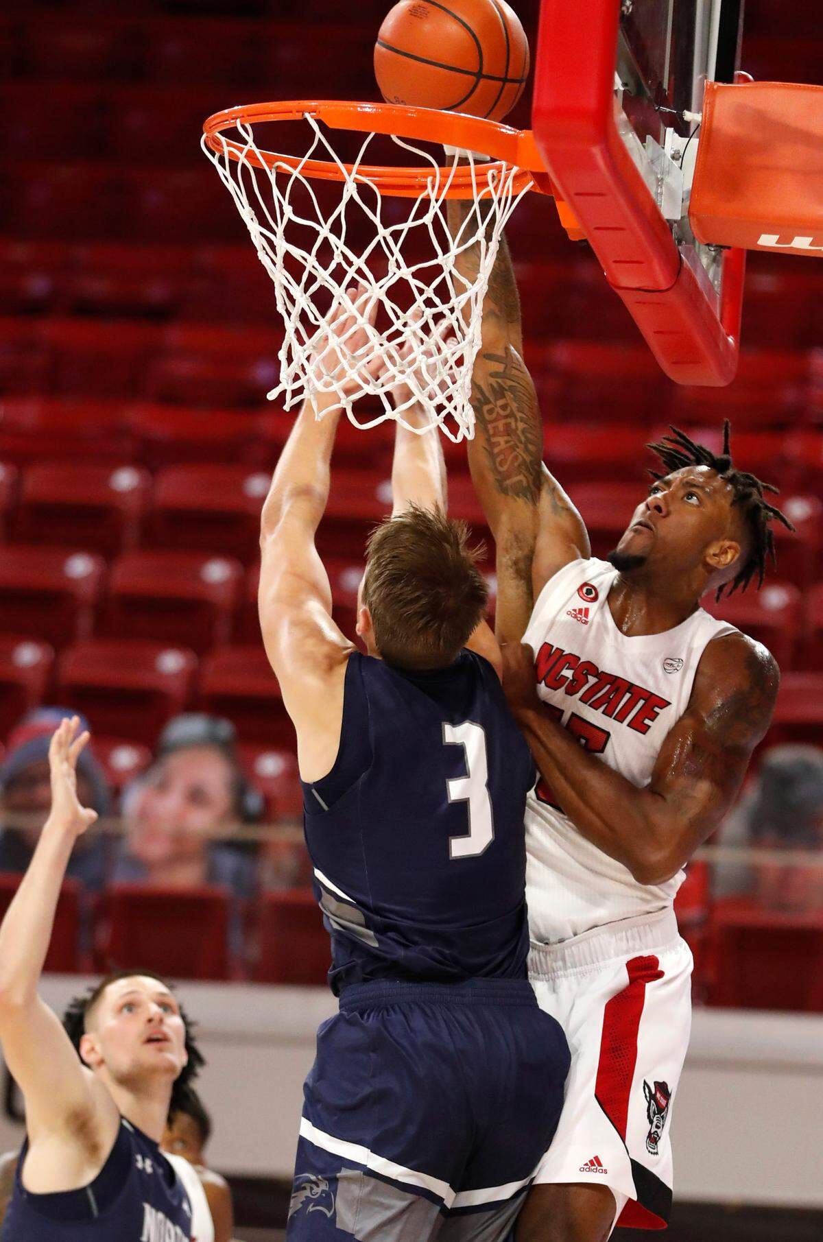 N.C. State’s Manny Bates (15) slams in two over North Florida’s Carter Hendricksen (3) during the first half of N.C. State’s game against North Florida in the Mako Medical Wolfpack Invitational at Reynolds Coliseum in Raleigh, N.C., Friday, Nov. 27, 2020.