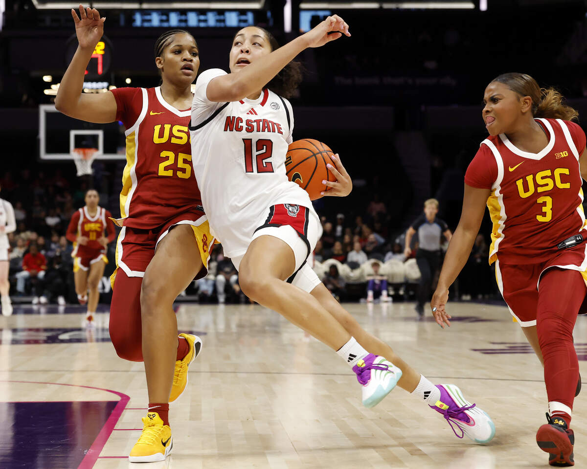 N.C. State’s Khamil Pierre drives past Southern California’s Kara Dunn and Londynn Jones during the second half of the Wolfpack’s 69-68 loss in the Ally Tipoff game on Sunday, Nov. 9, 2025, at Spectrum Center in Charlotte, N.C.