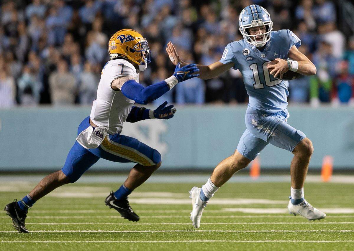 North Carolina quarterback Drake Maye (10) breaks away from Pitt’s SirVocea Dennis (7) for seven yards in the third quarter against Pitt on Saturday, October 29, 2022 at Kenan Stadium in Chapel Hill, N.C. Maye had 61 yards rushing in the Tar Heels’ victory.