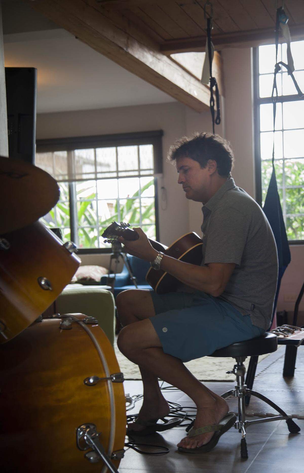 Matt Hedspeth strums a guitar at his home in Panama.