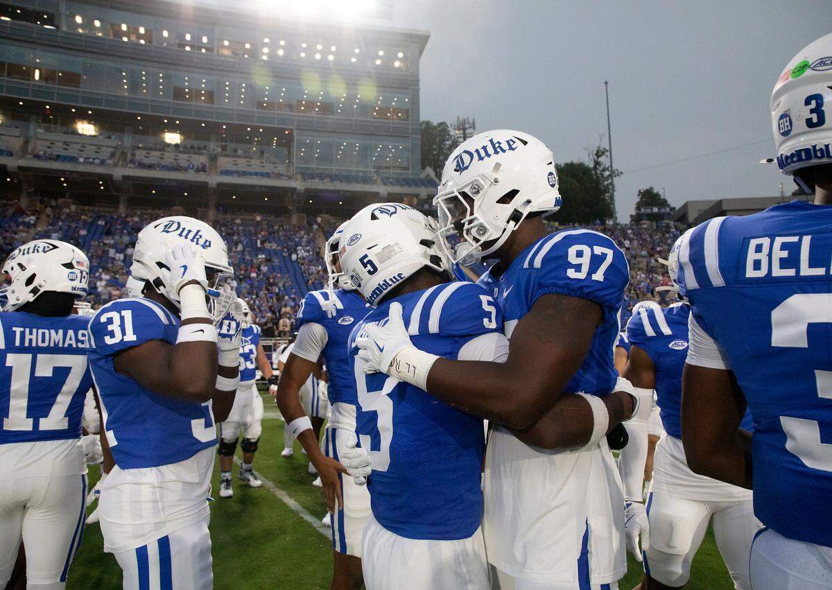 Duke’s Peyton Jones and Wesley Williams embrace prior to the start of the Blue Devils’ season-opening game against Elon on Friday, Aug. 30, 2024, at Wallace Wade Stadium in Durham, N.C.