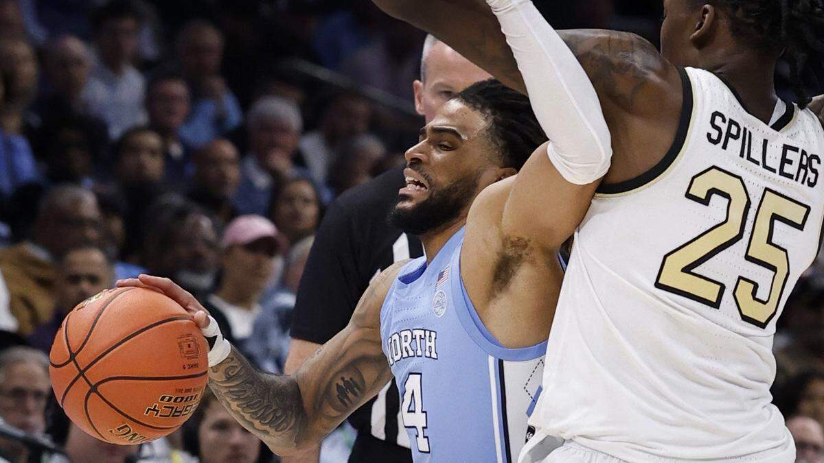 North Carolina’s RJ Davis (4) is fouled by Wake Forest’s Tre’Von Spillers (25) during the first half of UNC’s game against Wake Forest in the quarterfinals of the 2025 ACC Men’s Basketball Tournament at the Spectrum Center in Charlotte, N.C., Thursday, March 13, 2025.